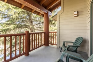 Enjoy your own private patio with two green chairs to relax in.