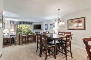 Snow Flower 135s dining area with a wood table, 6 dining chairs, and chandelier.