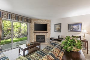 Snow Flower 135s living room with southwestern upholstered couch and gas fireplace with flat screen TV mounted above.