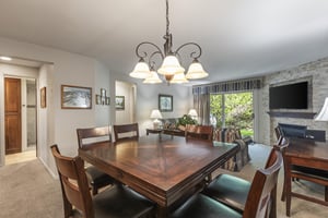 Snow Flower 135s dining area with a wood table, 6 dining chairs, and chandelier.
