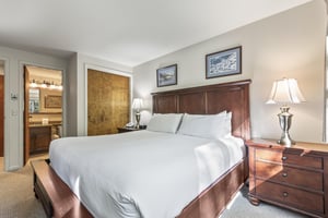 Snow Flower 135s bedroom with king bed, solid wood frame, white linens and pillows, and art above the bed.