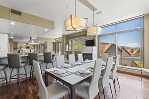 The Lowell 401 dining area has a table with seating for 8 on cream colored upholstered chairs.