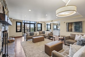 Lowell 401 has a spacious living area with two large sectional sofas and floor to ceiling windows behind it.