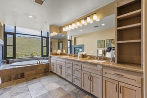 The main bedrooms en suite bathroom has a long twosink vanity, mirror and lighting.