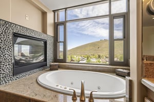 The main bedrooms, en suite bathroom has a deep jetted tub with with a built in gas fireplace and window next to it.