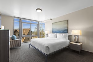 The third bedroom has a king size bed and views out of floor to ceiling windows.