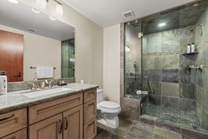 The third bedrooms shared bathroom located in the hall has a walk in shower and single seat vanity.
