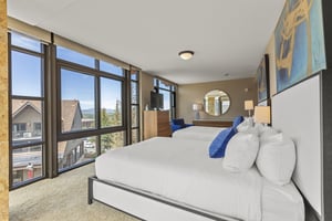 The second bedroom has two queen beds, crisp white linens, dresser, and TV.