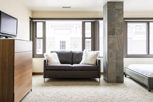 Grey upholstered sofa with white throw pillows.