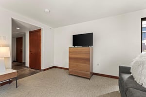 The fourth bedroom has a wooden dresser and TV.