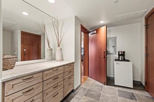 The entryway with built in cabinets, mini fridge and coffee pot.