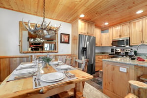 The dining table has an antler chandelier.