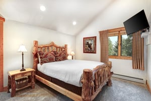 The second bedroom has a queen size bed and log style furniture.