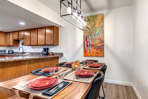 Park Station 133 has a dining table set for 6 guests, with a colorful paintings of aspens hanging on the wall.
