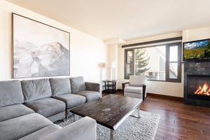Cozy fireplace in the living room with windows overlooking the resort plaza
