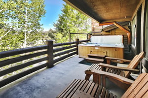 Private deck with wooden lounge chairs and spacious hot tub