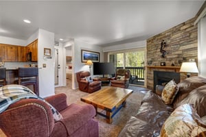 The open concept living room has two comfortable recliners and leather sofa.