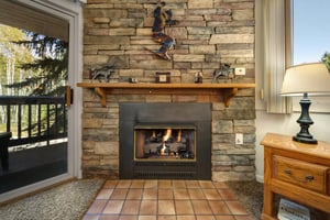 Living room features a gas fireplace with beautiful rock surround