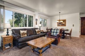 Living room includes comfortable seating on a leather sofa and red recliner.