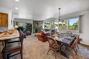 The open concept living room has two comfortable recliner, leather sofa, and dining room table..