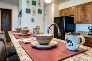 The kitchen breakfast bar offers seating and place settings for three guests.