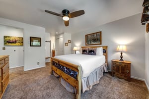 The main bedroom features a comfortable queensized bed with white linen