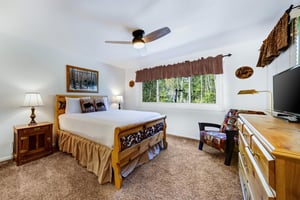 The main bedroom features a comfortable queensized bed with white linen