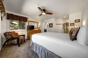 The main bedroom features a comfortable queensized bed with white linen