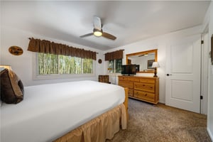 The main bedroom features a comfortable queensized bed with white linen