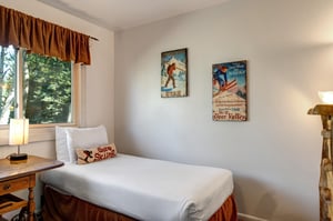 The second bedroom offers two twin beds with ski pillows, crisp white bedding and ski pictures on the wall.