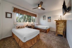 The second bedroom offers two twin beds with ski pillows, crisp white bedding and ski pictures on the wall.