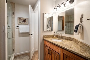 The second bedrooms shared bathroom has a  single vanity sink with granite countertop.