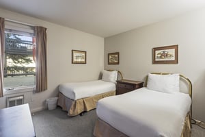 Snow Flower 135s second bedroom with two twin beds with white linens and pillows, and art above each bed.