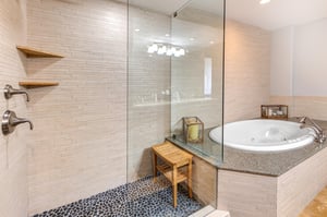 Lowell 402 main suite bathroom with double sink vanity, walk in shower and bathtub.