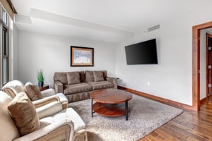 Lowell 402 living room with comfortable seating and flat screen TV.