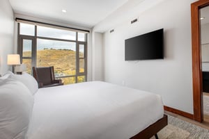 Lowell 402 main suite with a king size bed and a flat screen TV.