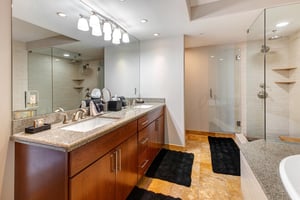 Lowell 402 main suite bathroom with double sink vanity, walk in shower and bathtub.