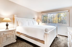 The main suite offers a king size bed and large window with forest views.