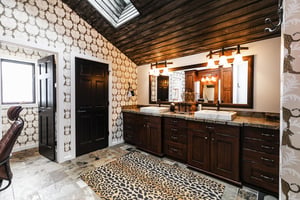 Ensuite private main bathroom with dual sinks, cheetah print rug and safari wallpaper for unique design