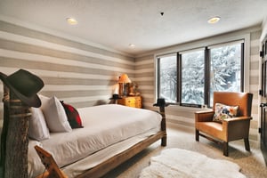 Aspen Hollow 6 offers a stylish bedroom with a full size bed and views of snow covered trees.