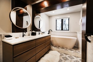 A bathroom with two sink vanity and free standing soaker bathtub.