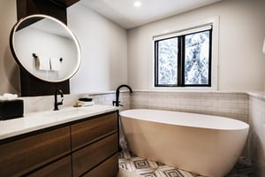 A bathroom with two sink vanity and free standing soaker bathtub.