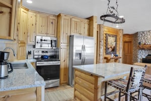 Comstock 203 offers a well equipped kitchen with stainless steel appliances, wood cabinets and island with seating for two.