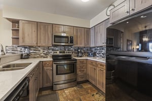 Snow Flower 127 has a wellequipped kitchen with wood cabinets and black and stainless steel appliances.