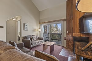 Snow Flower 127s living room with cozy couches and gas burning fireplace.