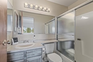The en suite bathroom has a single sink vanity and bathtub and shower combination.