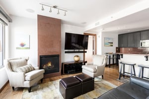 Beautifully appointed living room, hardwood floors, large flat screen wall mounted TV, and gas fireplace with 2 accent chairs