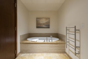 Main bathroom with large soaker tub and heated towel rack