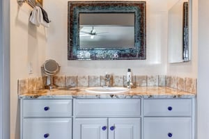 The en suite bathroom has a single sink vanity.
