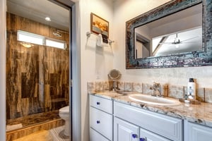 The en suite bathroom has a single sink vanity and separate water closet.